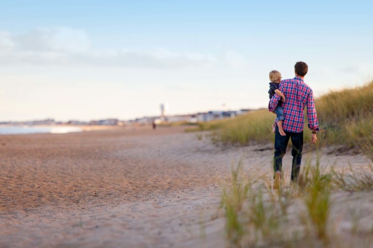 What Is Disability Insurance? A father and his child walking on the beach.