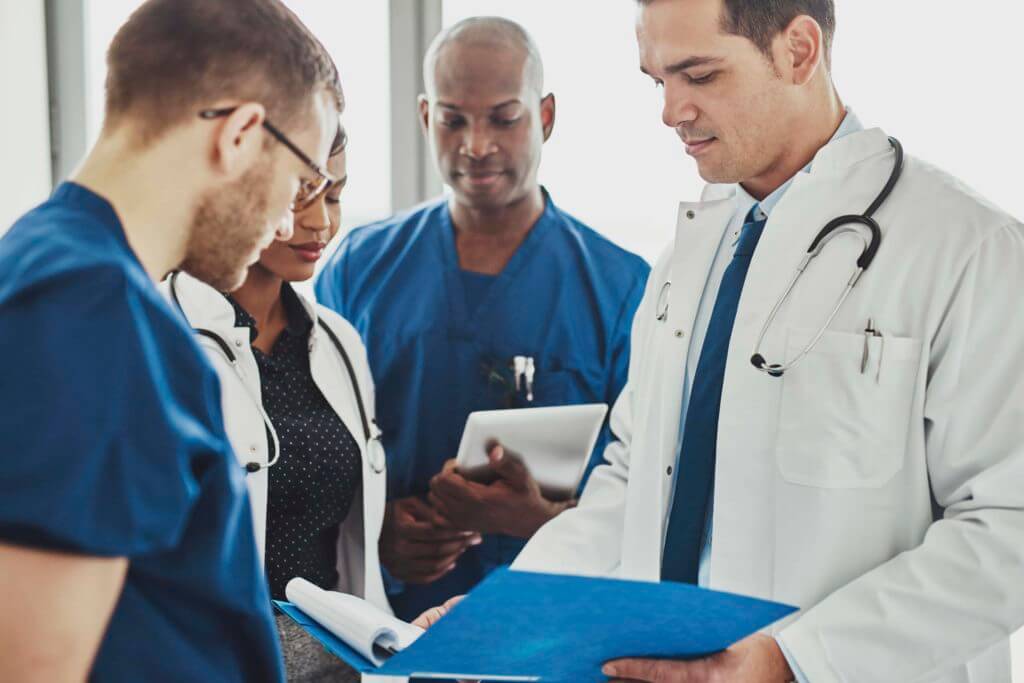 Contract Review Doctors having a conversation looking at documents, mixed races, surgeons and doctors