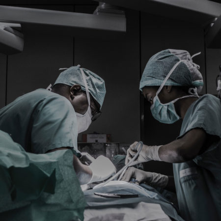 piron-guillaume-492636-unsplash Two physicians in surgery, leading over a table