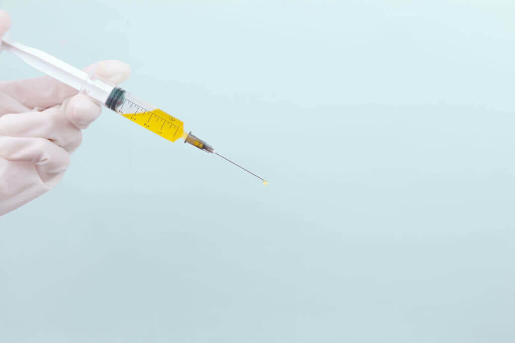 Doctor's hand holding syringe
