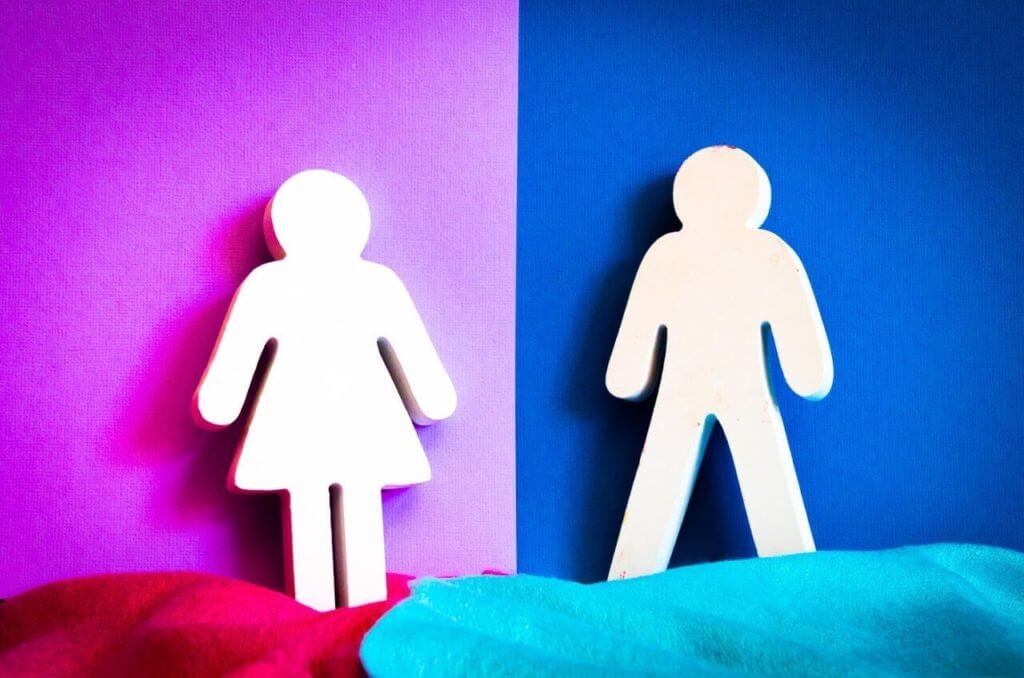 Man and woman cutouts placed next to each other against pink and blue backgrounds