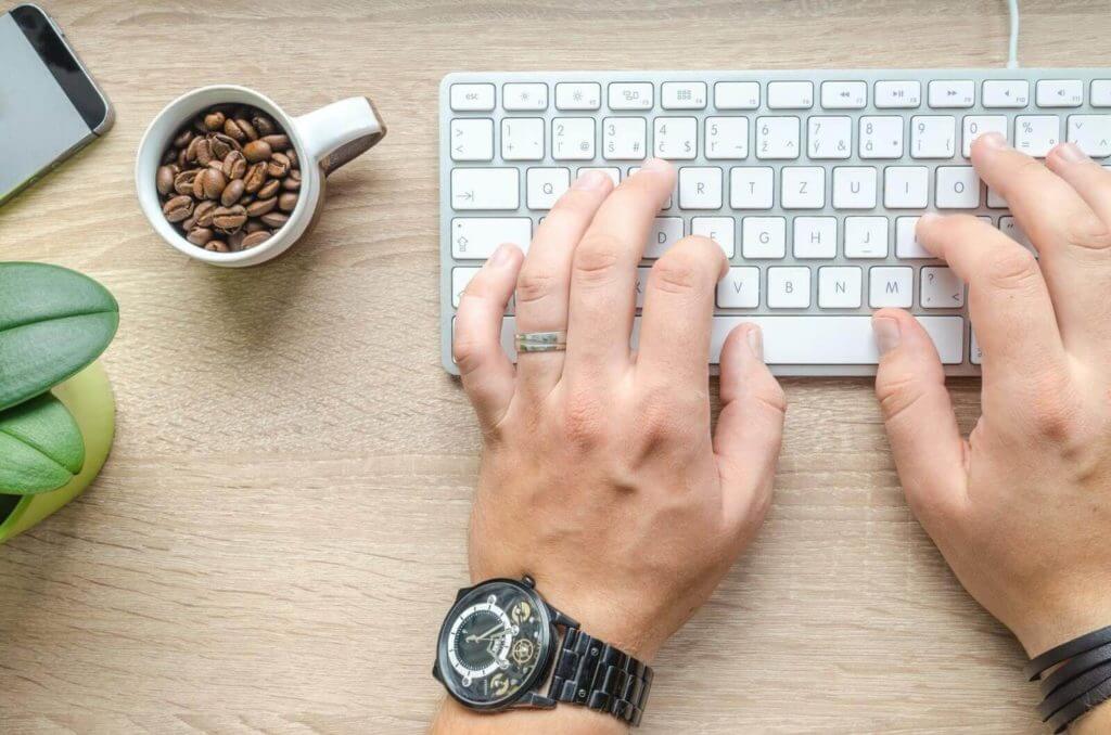 Hands typing on computer keyboard