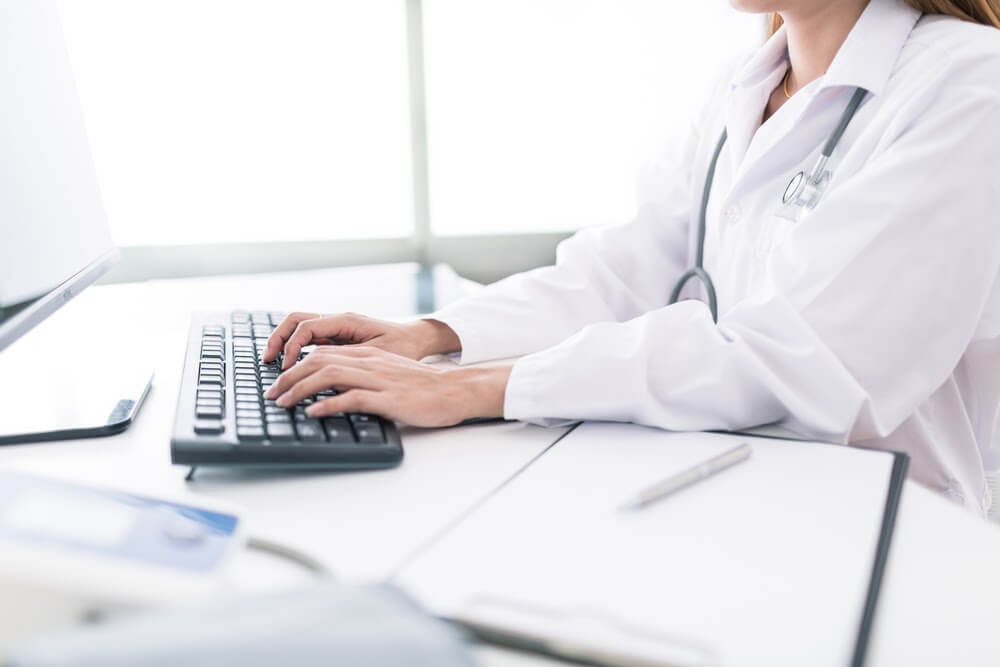 Physician typing on computer