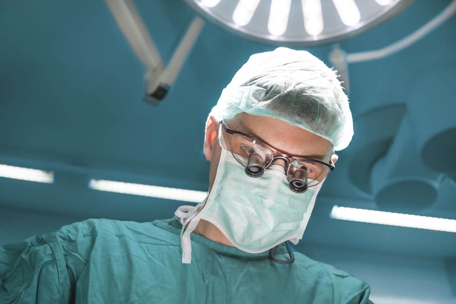 Surgeon wearing magnifying glasses performing a surgery